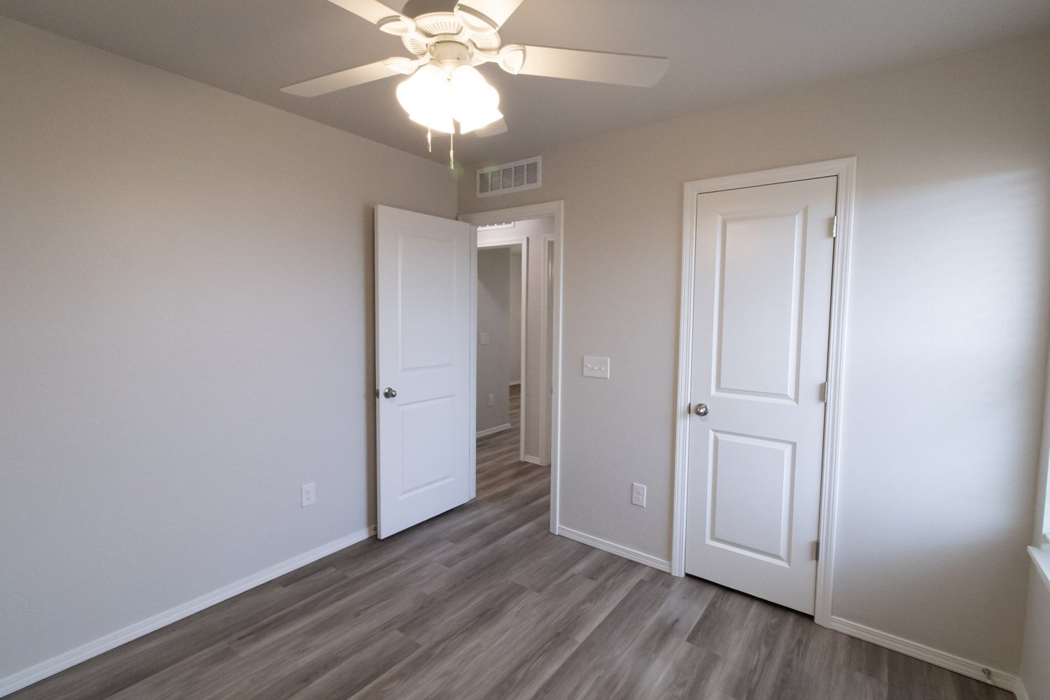 Bedroom with ceiling fan, closet, and wood-look flooring